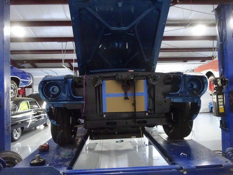 Blue classic car in auto repair shop.