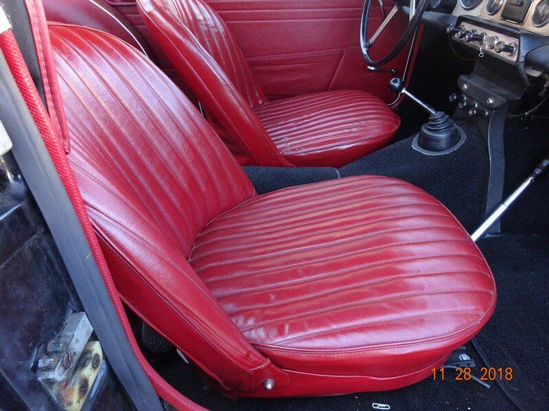 Red leather car seats, classic interior.