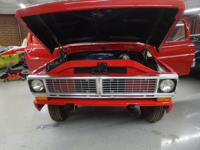 Red Ford F-100 truck engine detail.