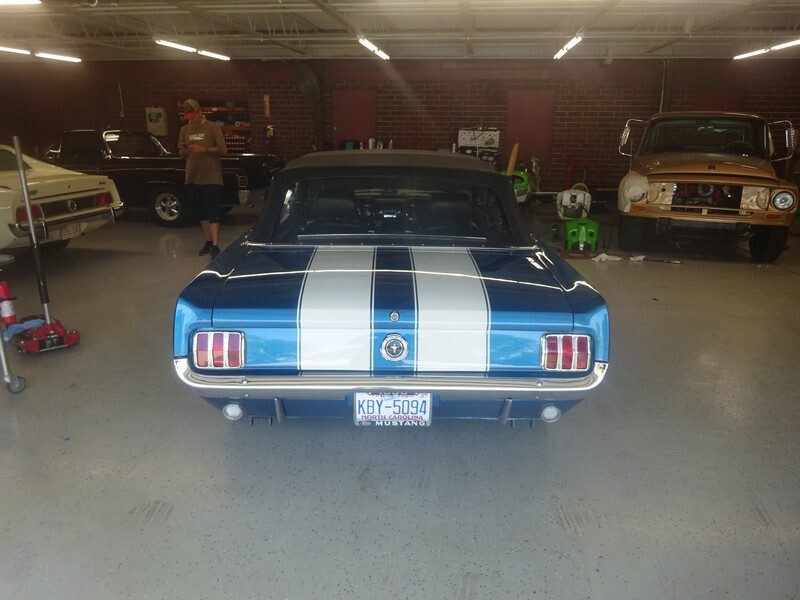 Blue Mustang convertible in garage.