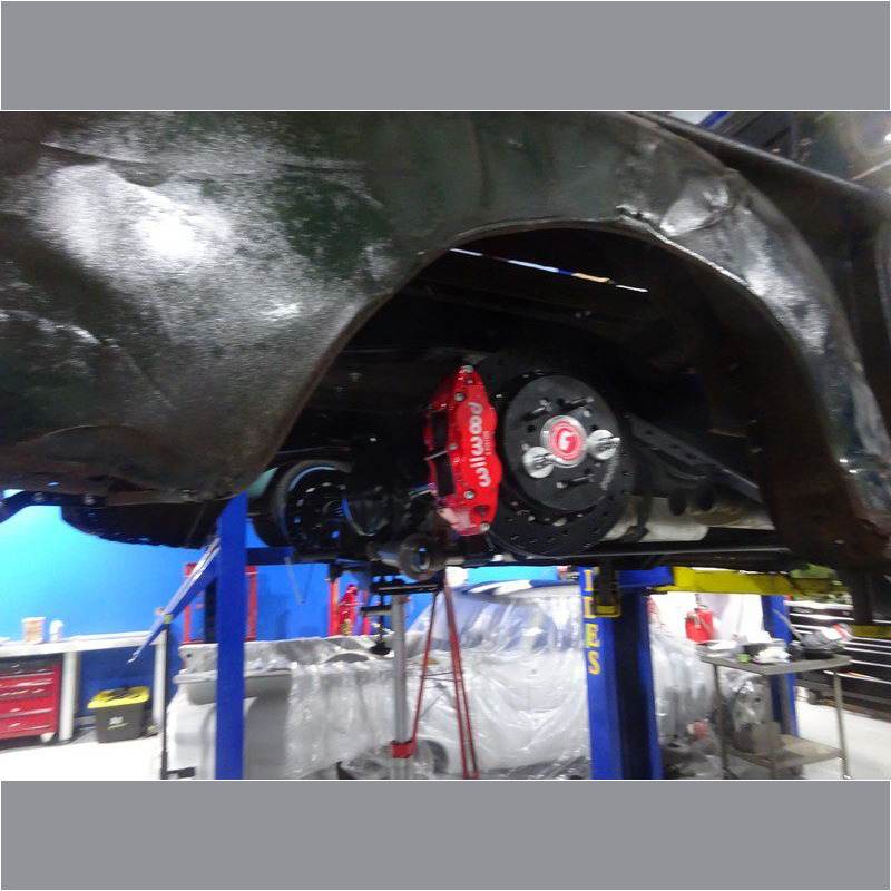 Red brake calipers on car in garage.