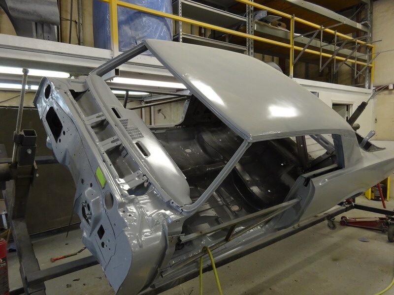 Grey car body in auto body shop.