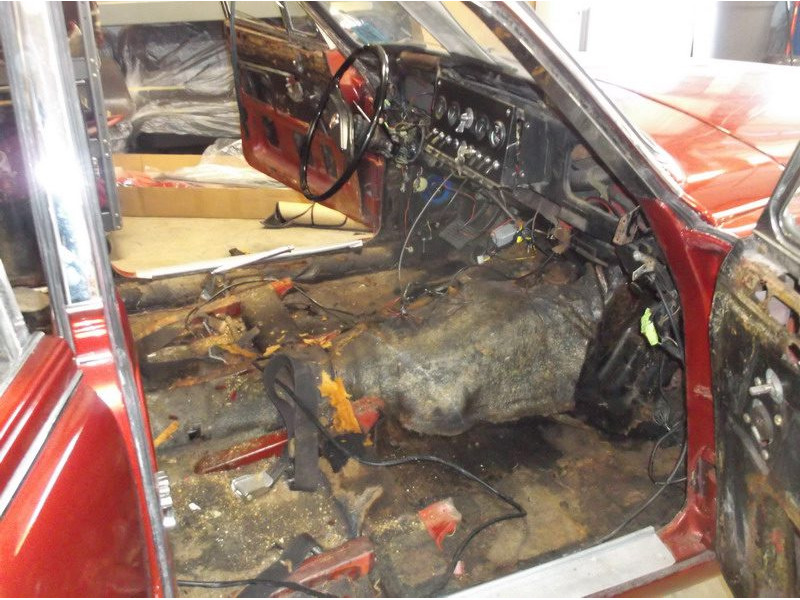 Stripped red car interior with exposed wiring