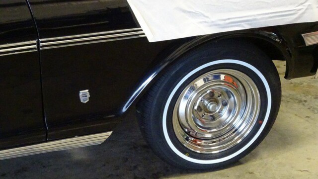 Black classic car with chrome wheel.