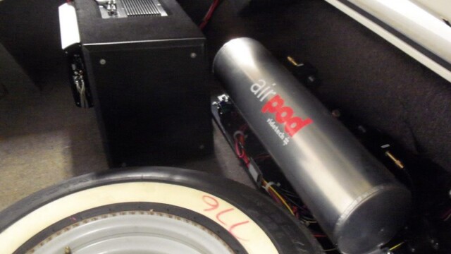 Car trunk with amp and air tank.