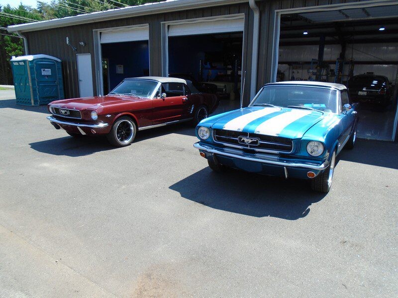 Two classic Ford Mustangs parked.