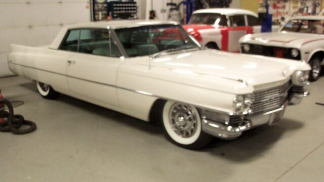 White classic Cadillac in garage.