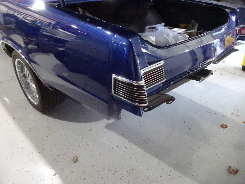 Here's an alt tag for the image: Blue classic car's rear end.