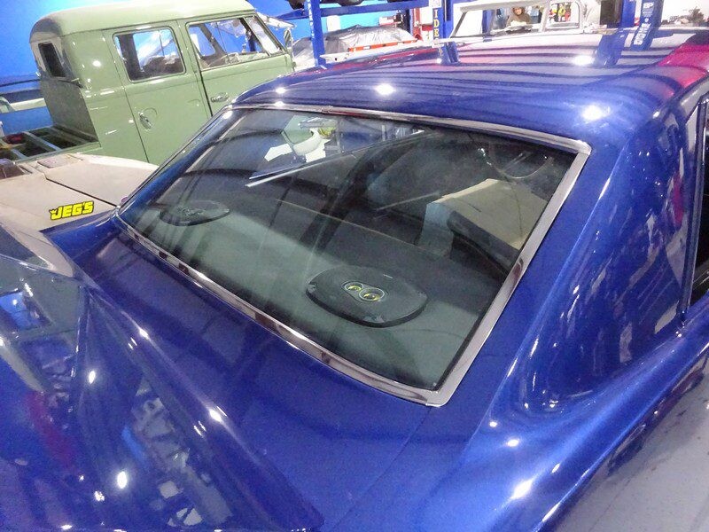 Blue classic car's rear window detail.
