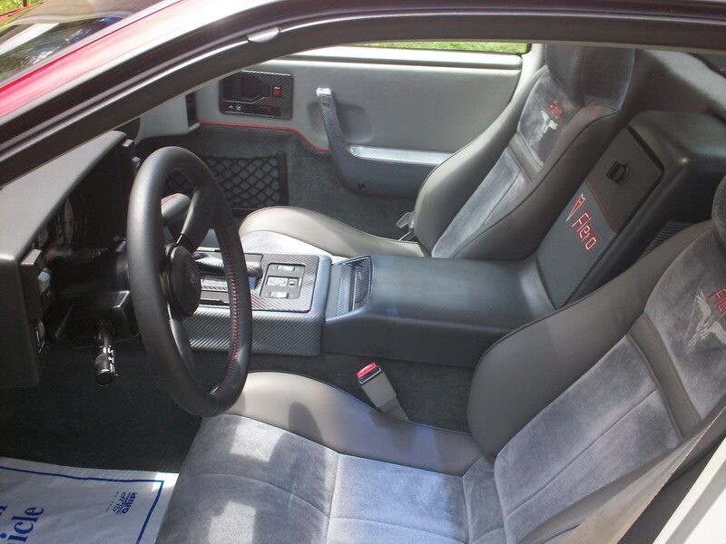 Here's an 8-word alt tag for the image: Grey interior of a Pontiac Firebird Fiero.