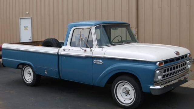 Vintage blue and white Ford 100 pickup truck.