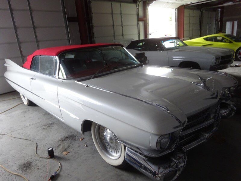 Classic white Cadillac convertible in garage.