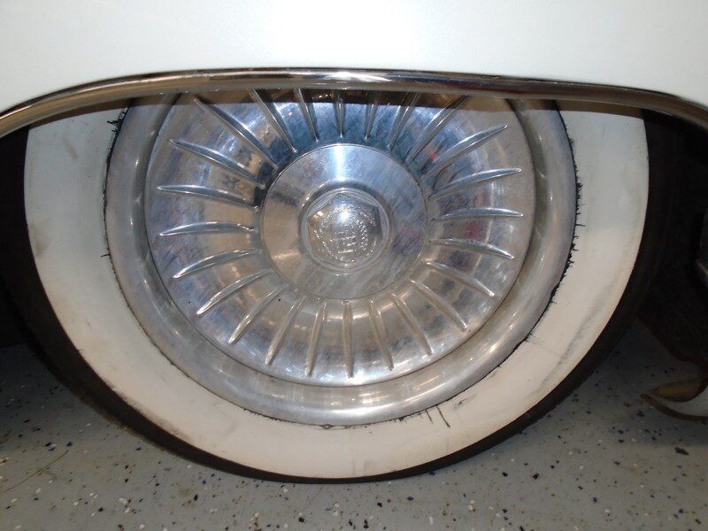 Classic car wheel with whitewall tire.
