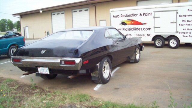 Black Ford Torino at auto shop.