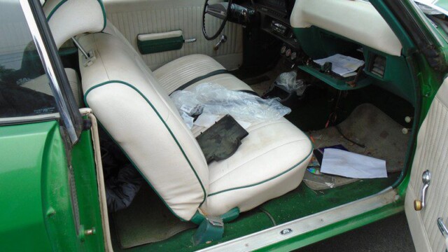 Green classic car interior, off-white seats.