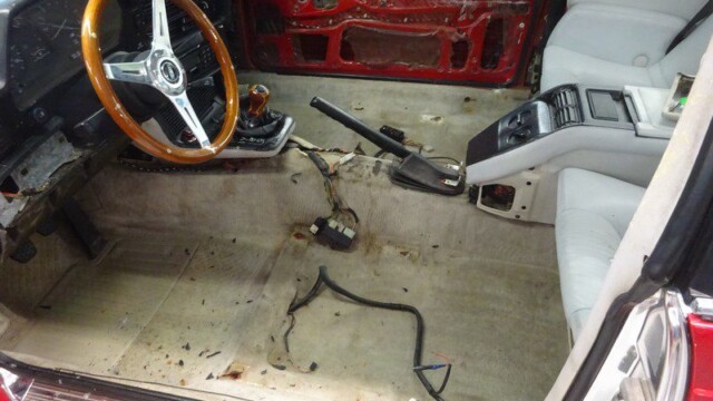 Stripped-down car interior needing repair.