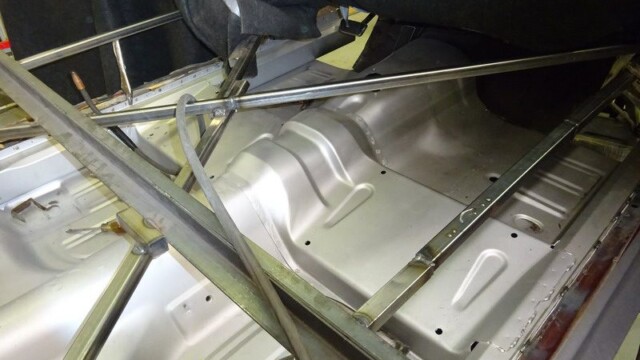 Car floor pan with metal frame.