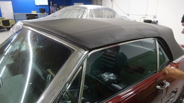 Red classic Mustang convertible top up.