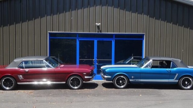 Two classic Ford Mustangs parked outside.