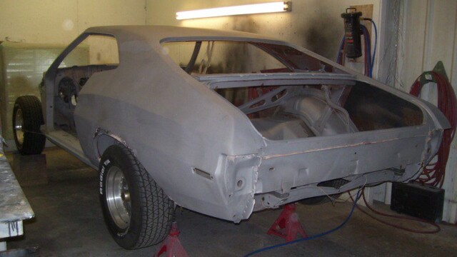 Stripped muscle car shell in workshop