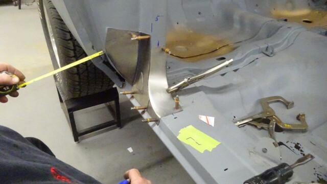Car body repair: measuring new panel.