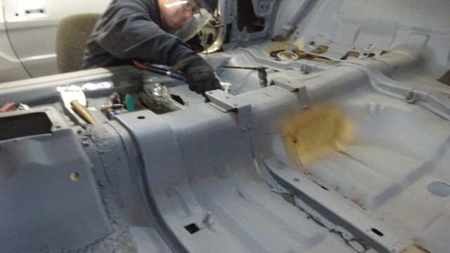 Mechanic repairing car's interior floor.