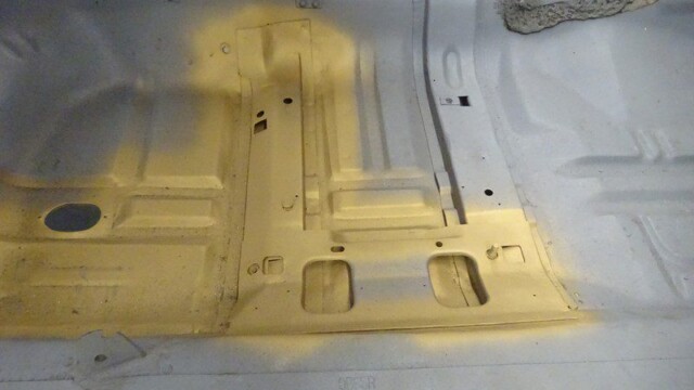 Painted car floor pan with cutouts.