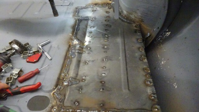 Welded car floor panel repair in progress.