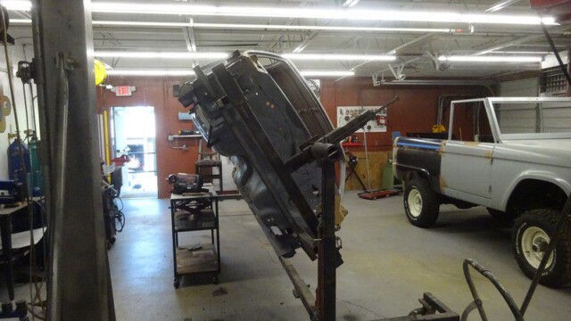 Car body on a hoist in a garage.