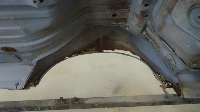 Rusty car body panel needing repair.