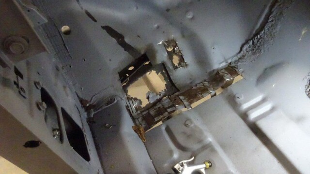 Car body repair, rust removal in progress.