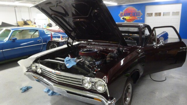 Dark maroon classic El Camino under repair.