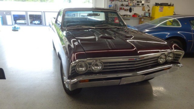 Dark red classic El Camino in garage.