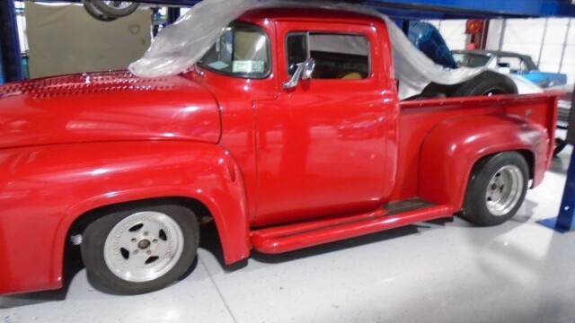 Red 1956 Ford F-100 pickup truck.