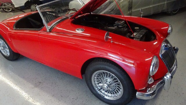 Red MG Midget classic car, hood up.