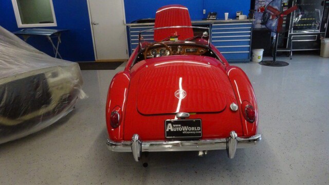 Red MG sports car in auto shop.