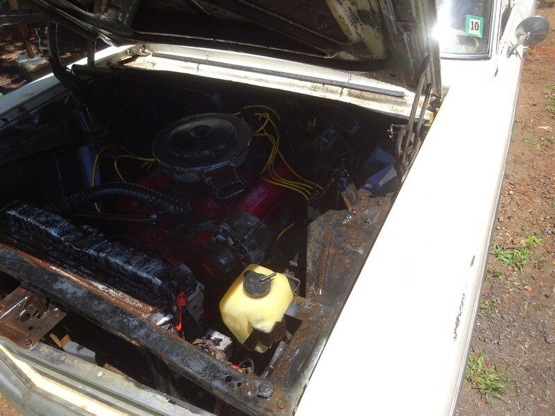 Sunlit red V8 with yellow wires and corrosion