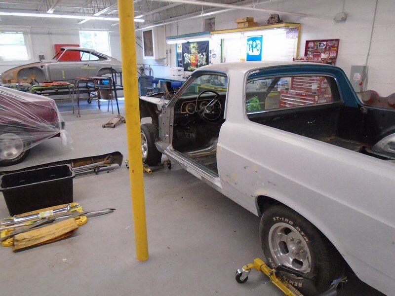 Auto shop with primered coupe on dollies