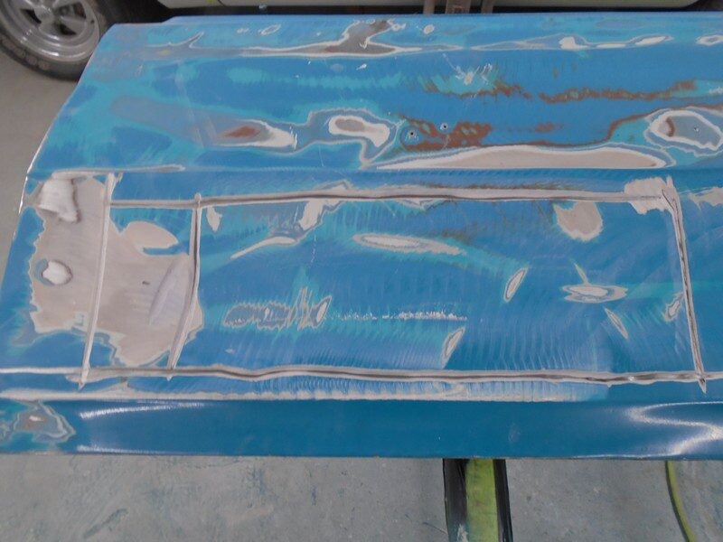 Sanded blue car door with exposed metal patches