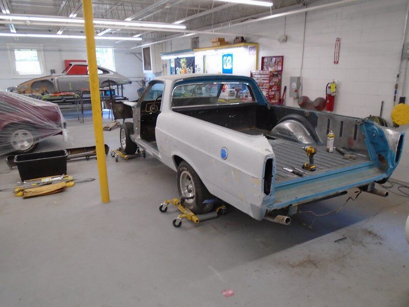 Classic car undergoing restoration in shop.