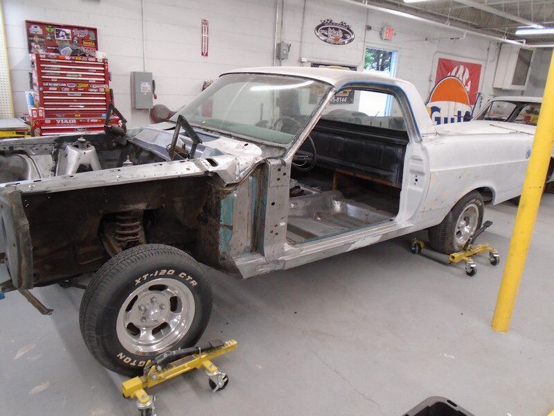 Ranchero body on wheel dollies in garage