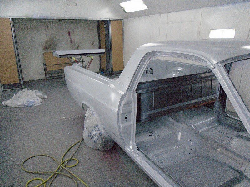 Primered classic truck in paint booth.