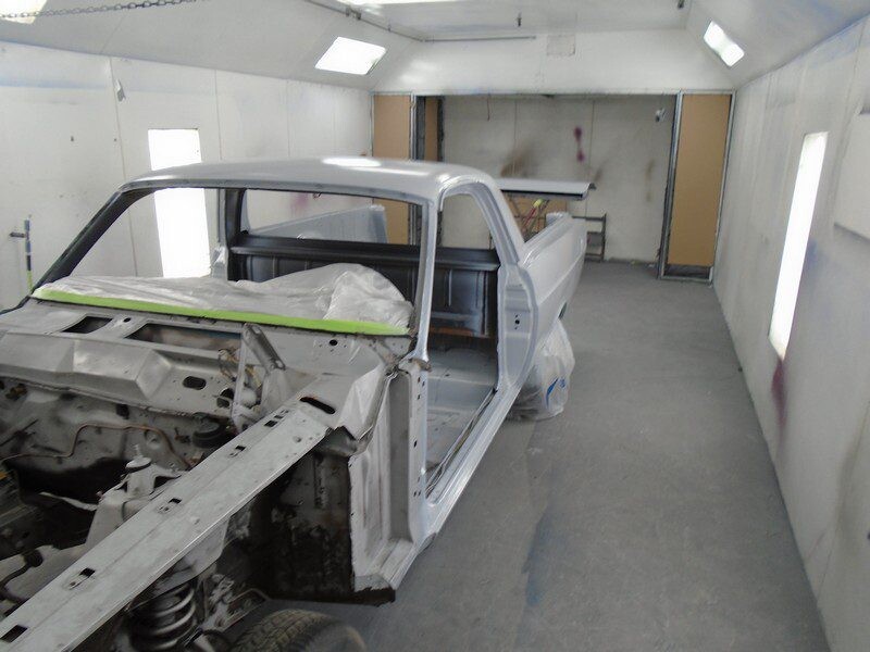 Classic car in paint booth, primered.