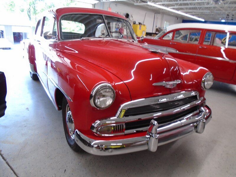 Red classic Chevrolet car in garage.