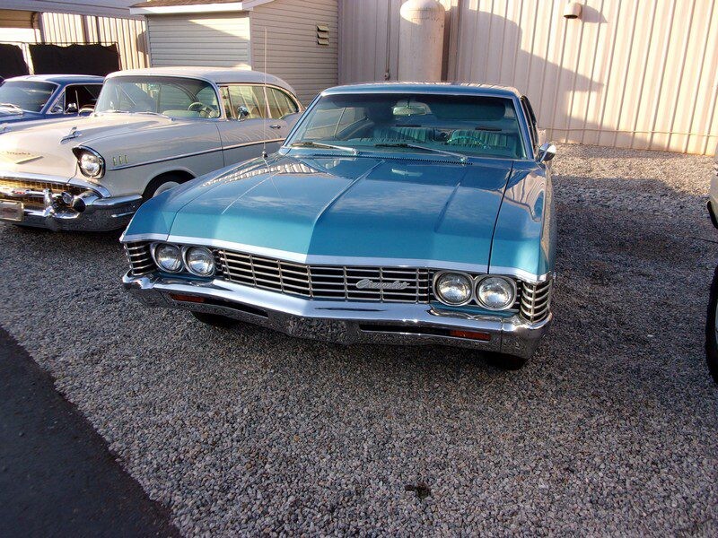 Classic teal Chevrolet Impala parked.