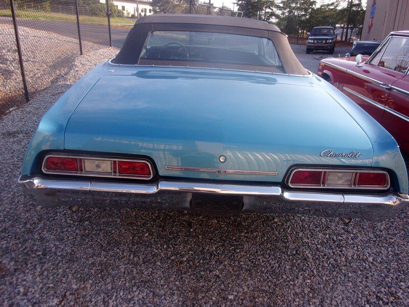 Here's an alt tag for the image: Blue Chevrolet Impala convertible rear view.