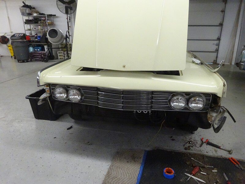 Classic car under repair in garage.