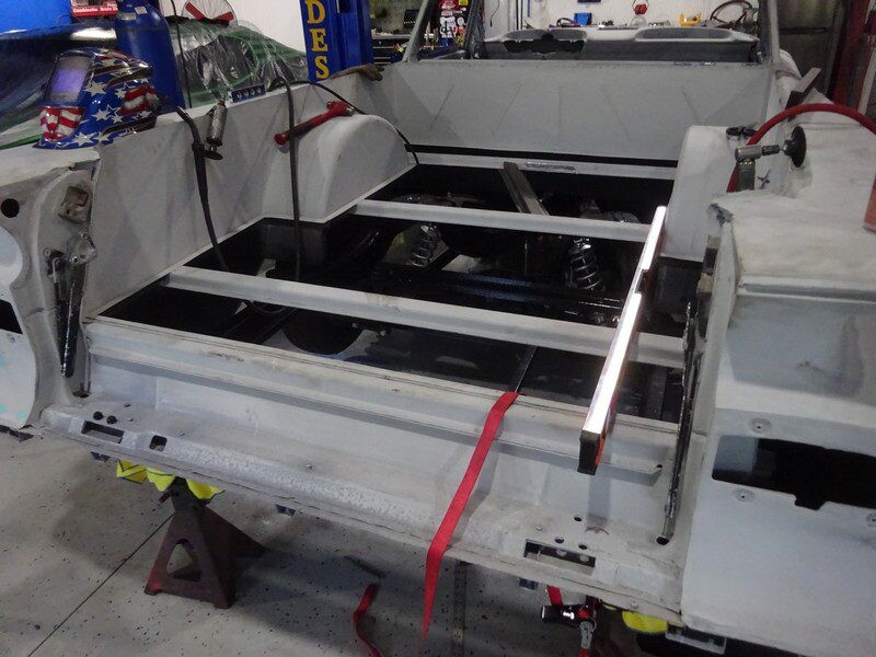 Rear frame rails and suspension in trunk