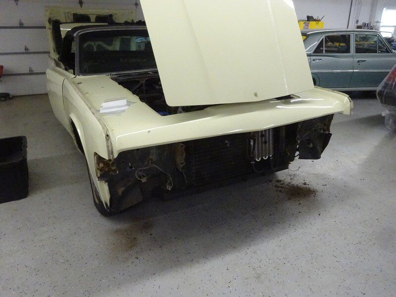 Damaged vintage Lincoln convertible under repair.