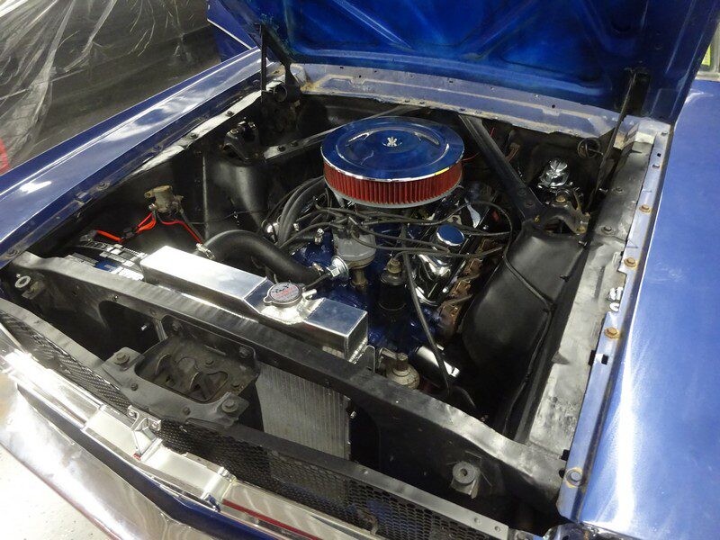 Blue classic car engine with chrome air cleaner